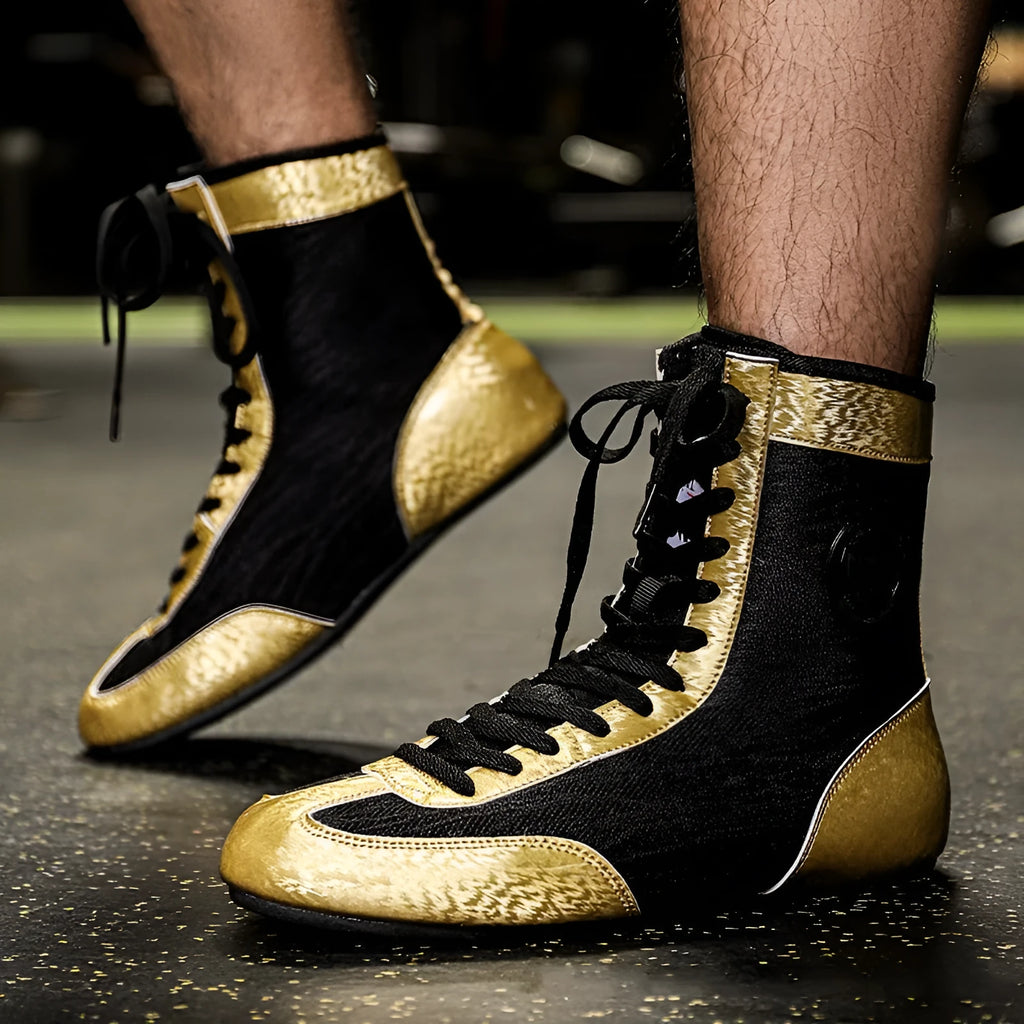Professional boxing shoes with leather and mesh construction in black gold colour with non-slip soles