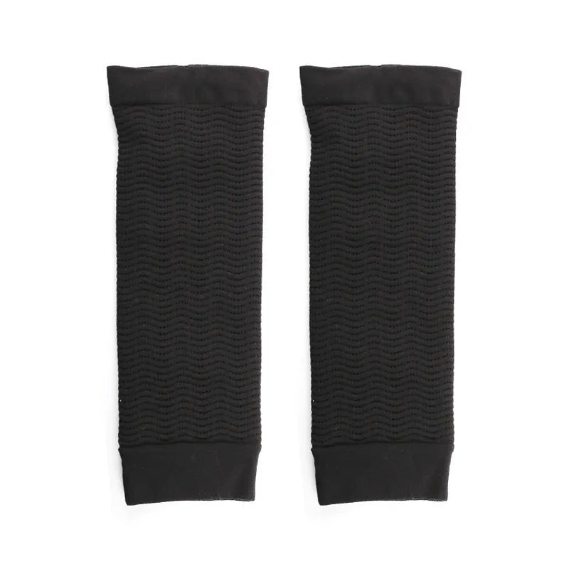 Pair of women's black shaping arm sleeves made from nylon fabric, laid flat.