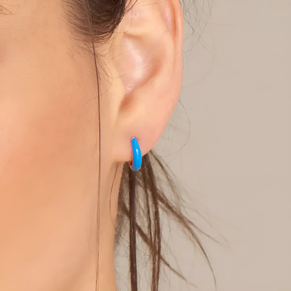 A pair of oval-shaped, U-curved epoxy earrings in a solid colour on a plain background.