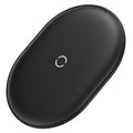 Baseus Rough 15W wireless charging pad in black on a table next to a mobile phone.