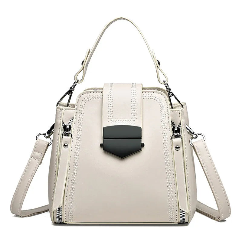 Small square vertical ladies handbag in soft textured PU leather, showing sewing thread detail.