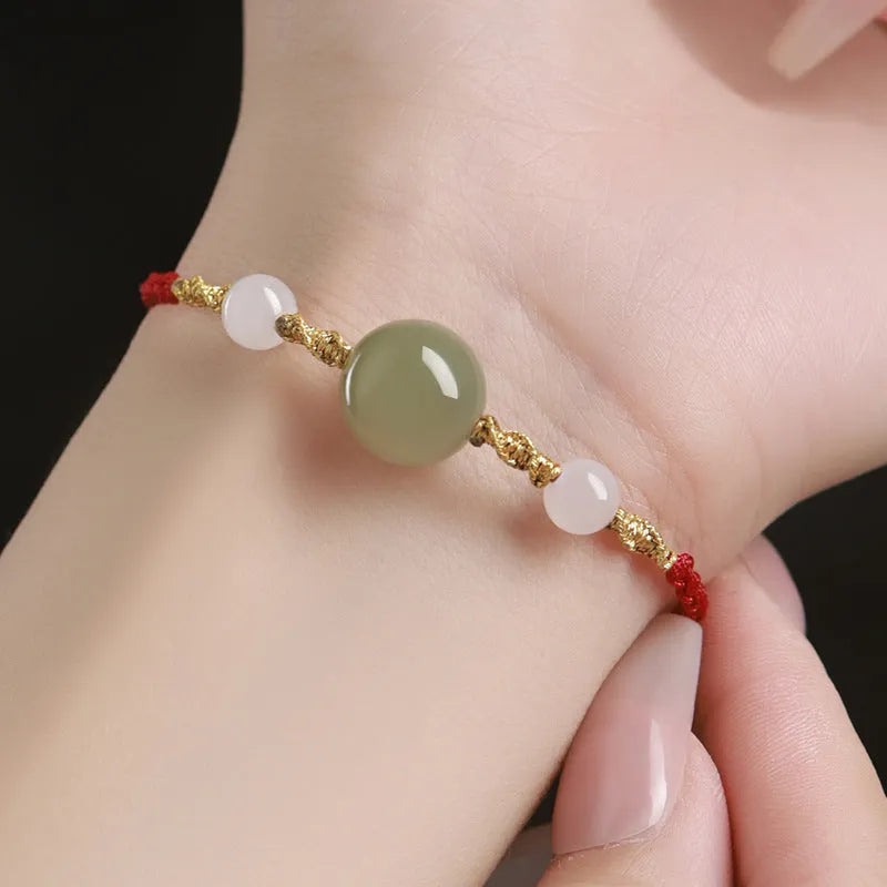 Hand-woven red rope bracelet with Hetian jade beads featuring traditional Chinese cultural symbols