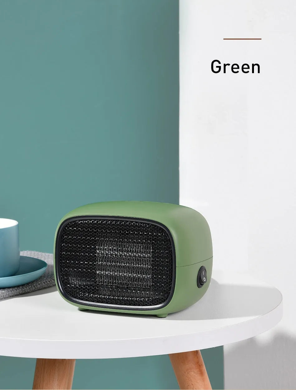 Compact green mini ceramic heater on a desktop showing its small size and EU plug.