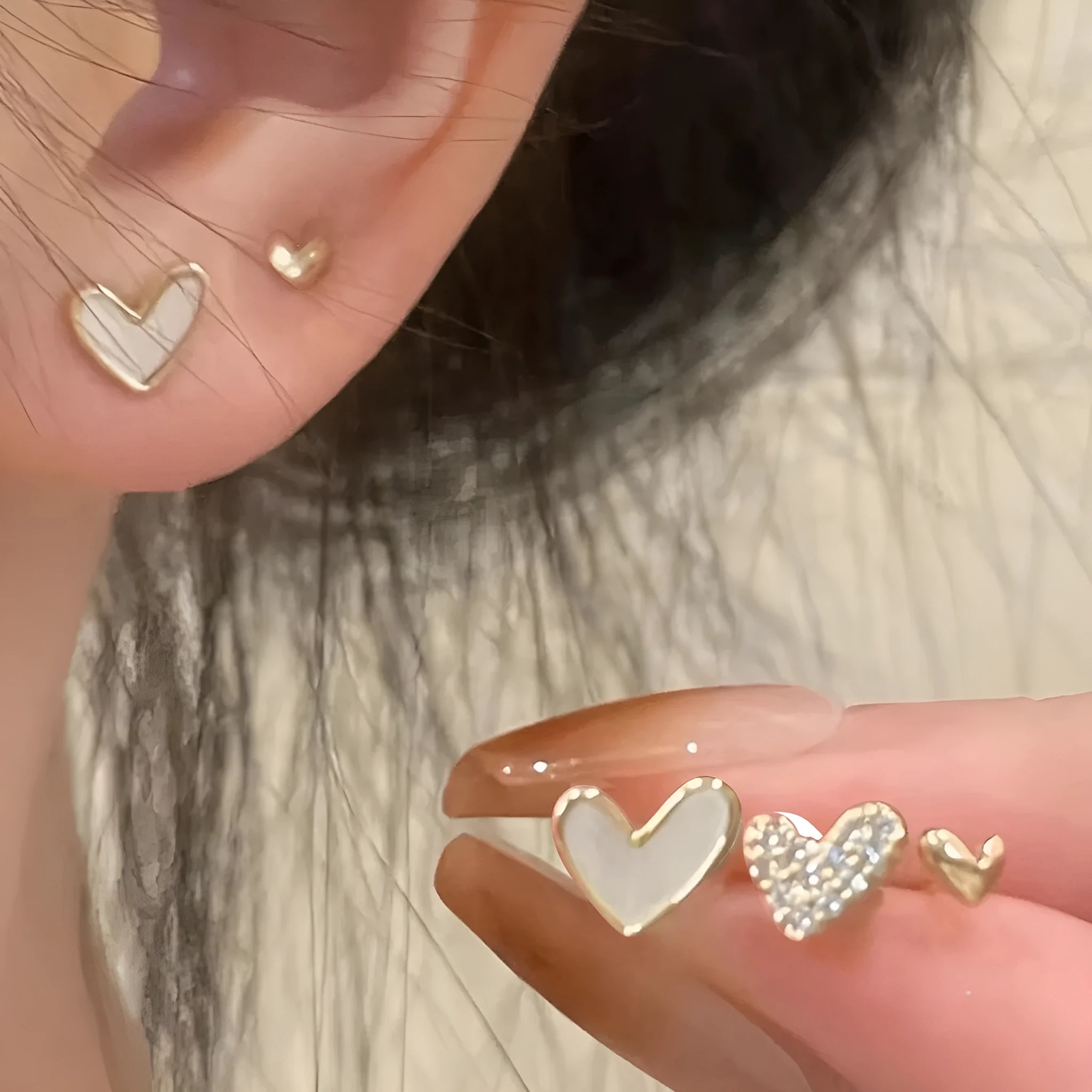 Set of three pairs of heart-shaped alloy earrings in gold, black, black and white, and pink colours