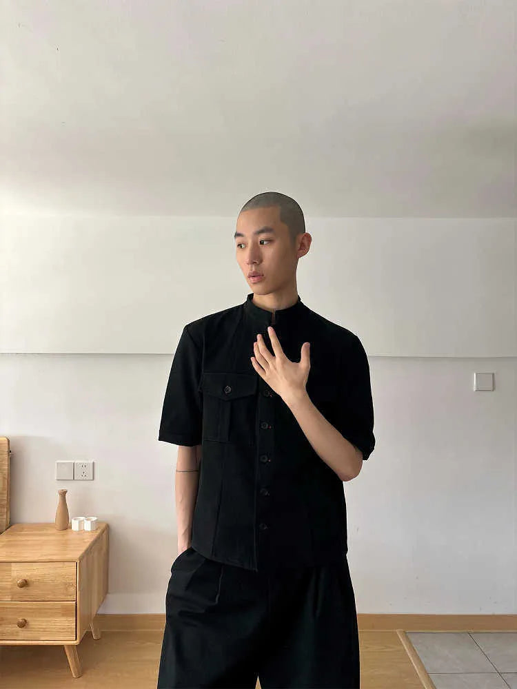 Handmade black loose-fit half sleeve hunting shirt with a shirt collar on a hanger.