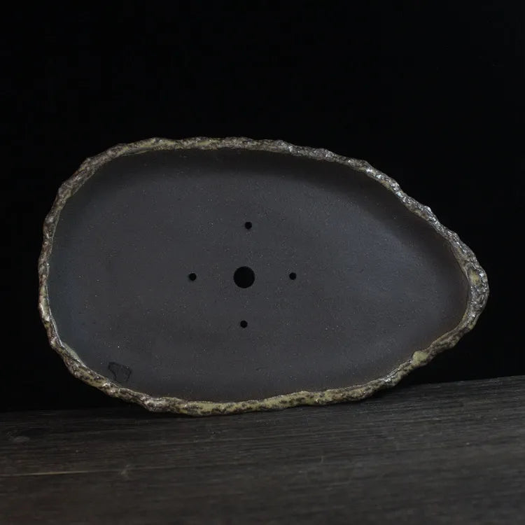 Handmade purple clay flower pot showing unique shape and natural ceramic texture