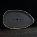 Handmade purple clay flower pot showing unique shape and natural ceramic texture