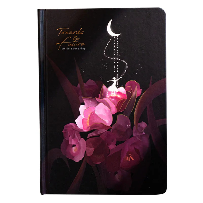 A5 notebook with a luminous cover shown in deep blue, open to reveal pages with colour illustrations.