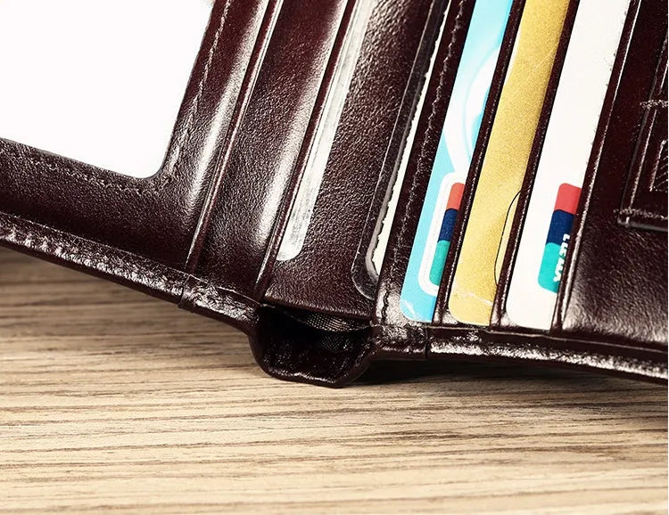 Men's black full-grain leather bifold wallet open, showing eight card slots and a zipped coin pocket.