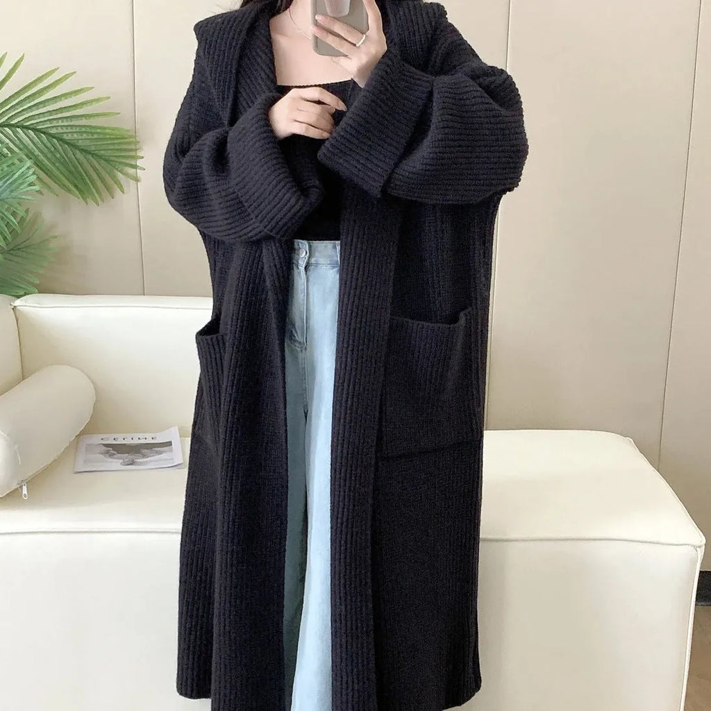 Loose-fitting beige hooded cardigan coat for women with raglan sleeves on a hanger.
