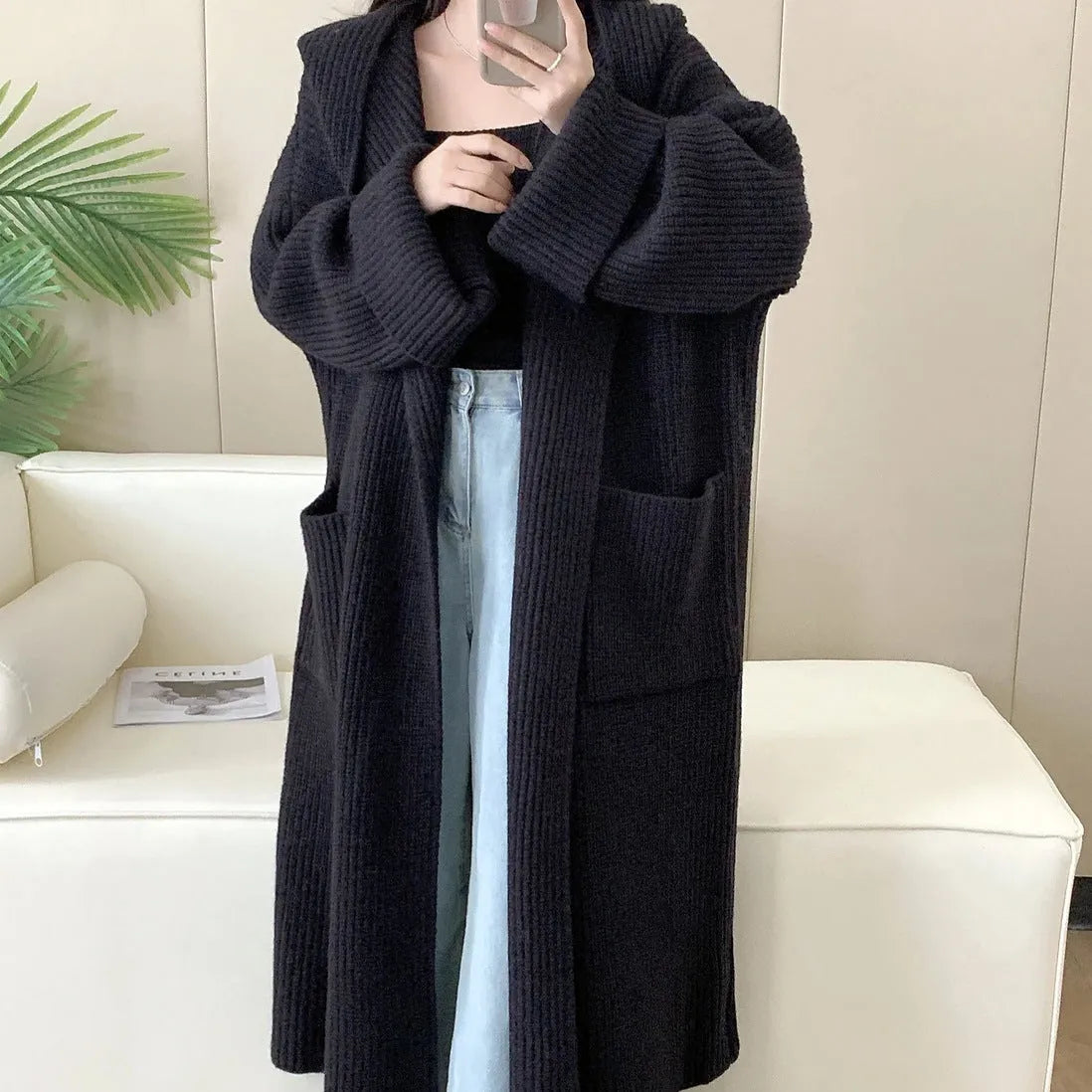Loose-fitting beige hooded cardigan coat for women with raglan sleeves on a hanger.