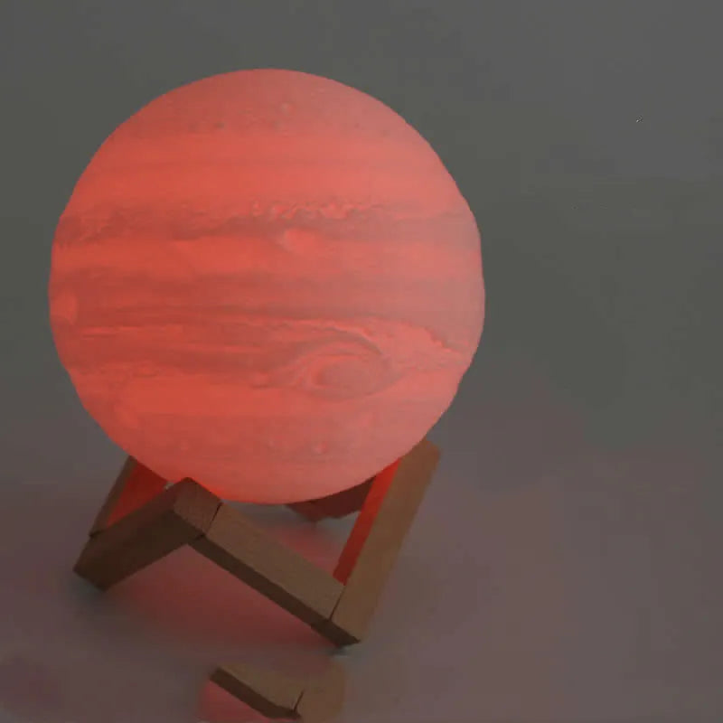 3D printed white moon lamp with detailed lunar surface texture on a wooden holder.