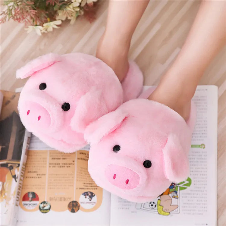 Pink pig-themed plush house slippers for adults on a plain background.