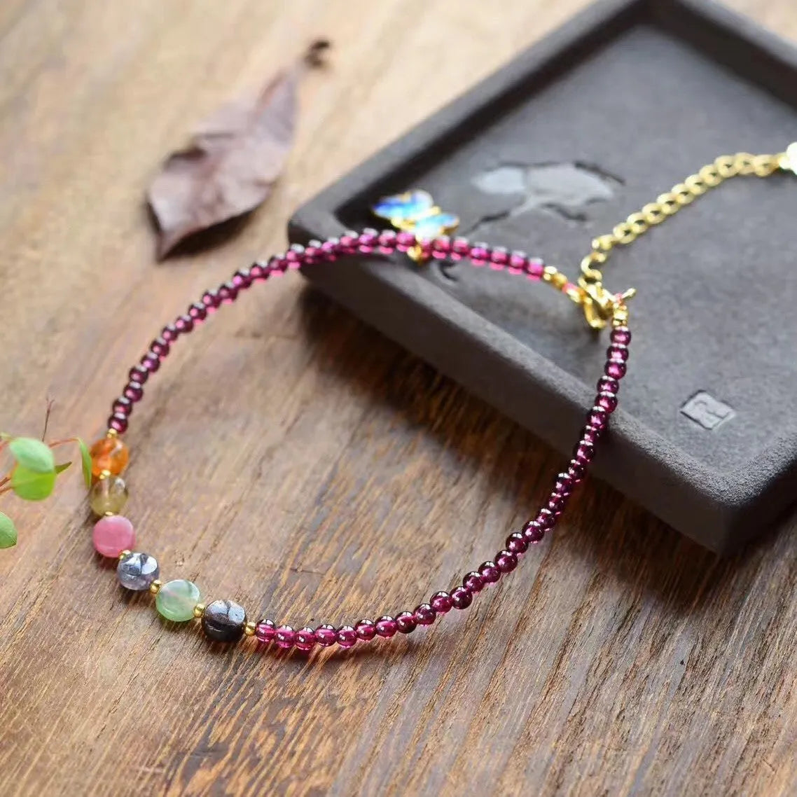Close-up of a purple garnet anklet with a geometric design on a female ankle.