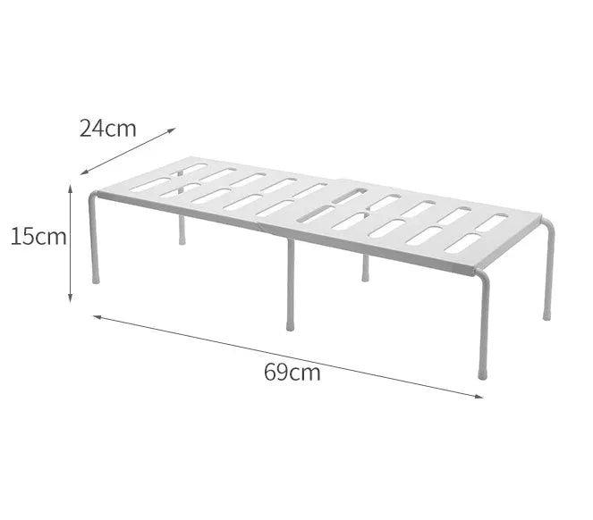 White telescopic plastic kitchen rack with single shelf, shown at adjusted height on a kitchen floor.