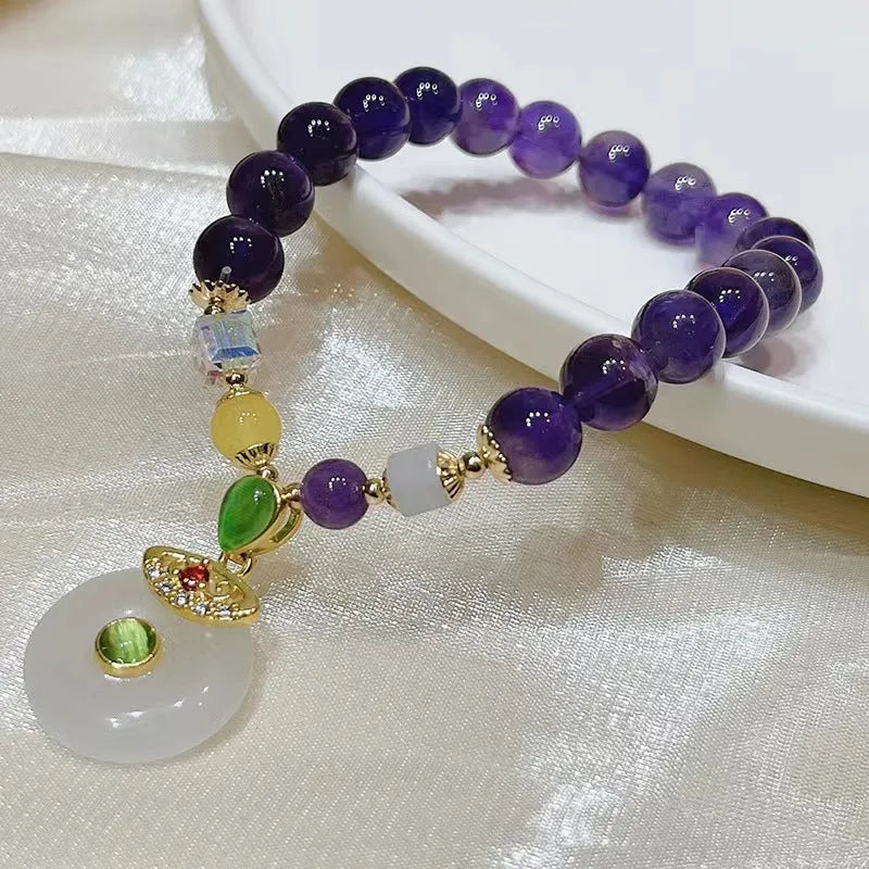 Purple amethyst crystal bracelet with money bag pendant and geometric peace buckle on wrist