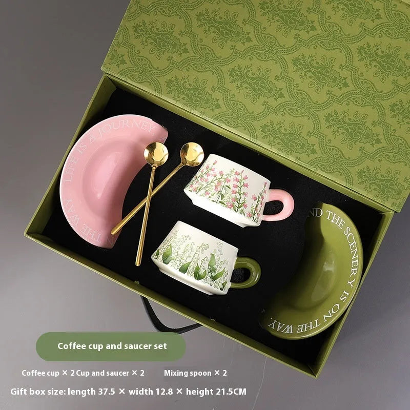 Ceramic coffee cup and saucer set for couples with two cups, saucers, and spoons.