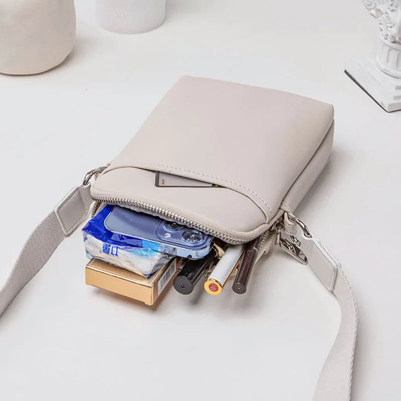 Solid colour small PU crossbody shoulder bag for mobile phones on a strap.