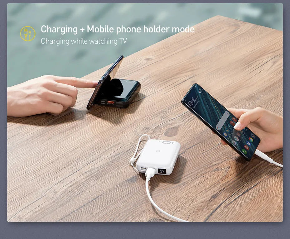 Small square black portable power bank with wireless charging surface and digital LED display.