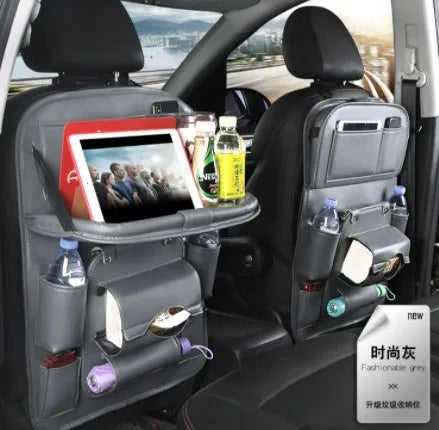 PU leather car seat back organiser with multiple pockets and a detachable bottom waste bin, hanging behind a car headrest.