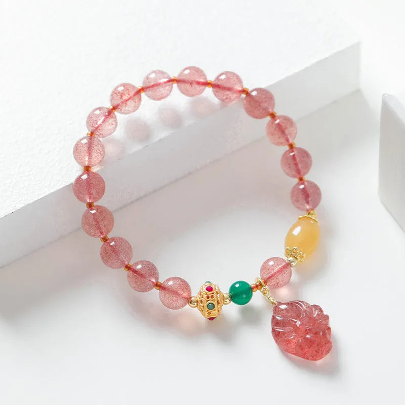 Women's polished crystal beaded bracelet with strawberry quartz and a nine-tail fox charm.