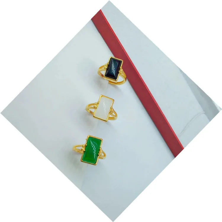 Adjustable brass gold-plated ring with a green gemstone inlay, showing national style design