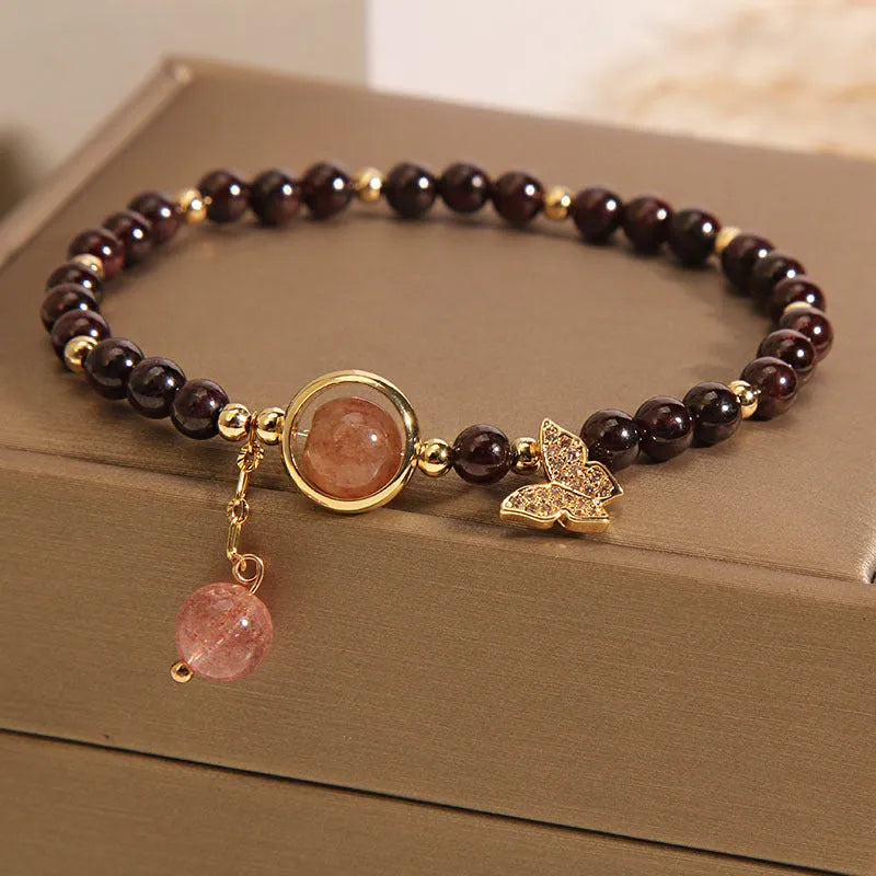 Black butterfly pendant bracelet with stone construction and red rock elements