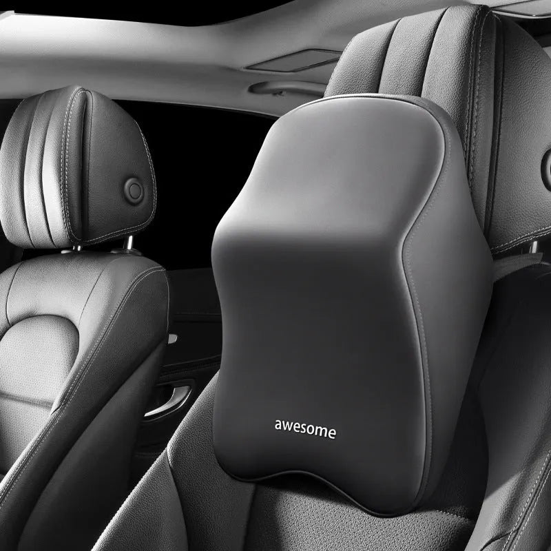 Black geometric pattern memory foam car lumbar pillow and matching headrest on a car seat.