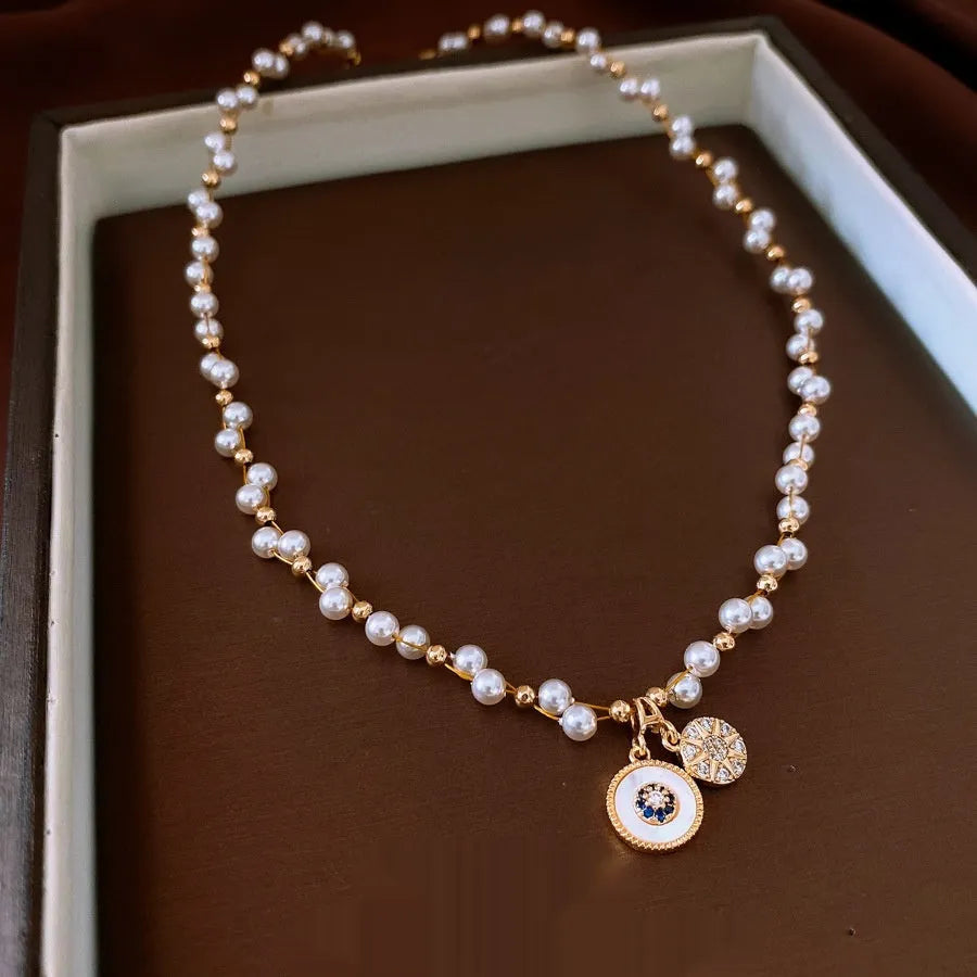 Gold-plated necklace with round pearl pendant and zircon accents on adjustable chain