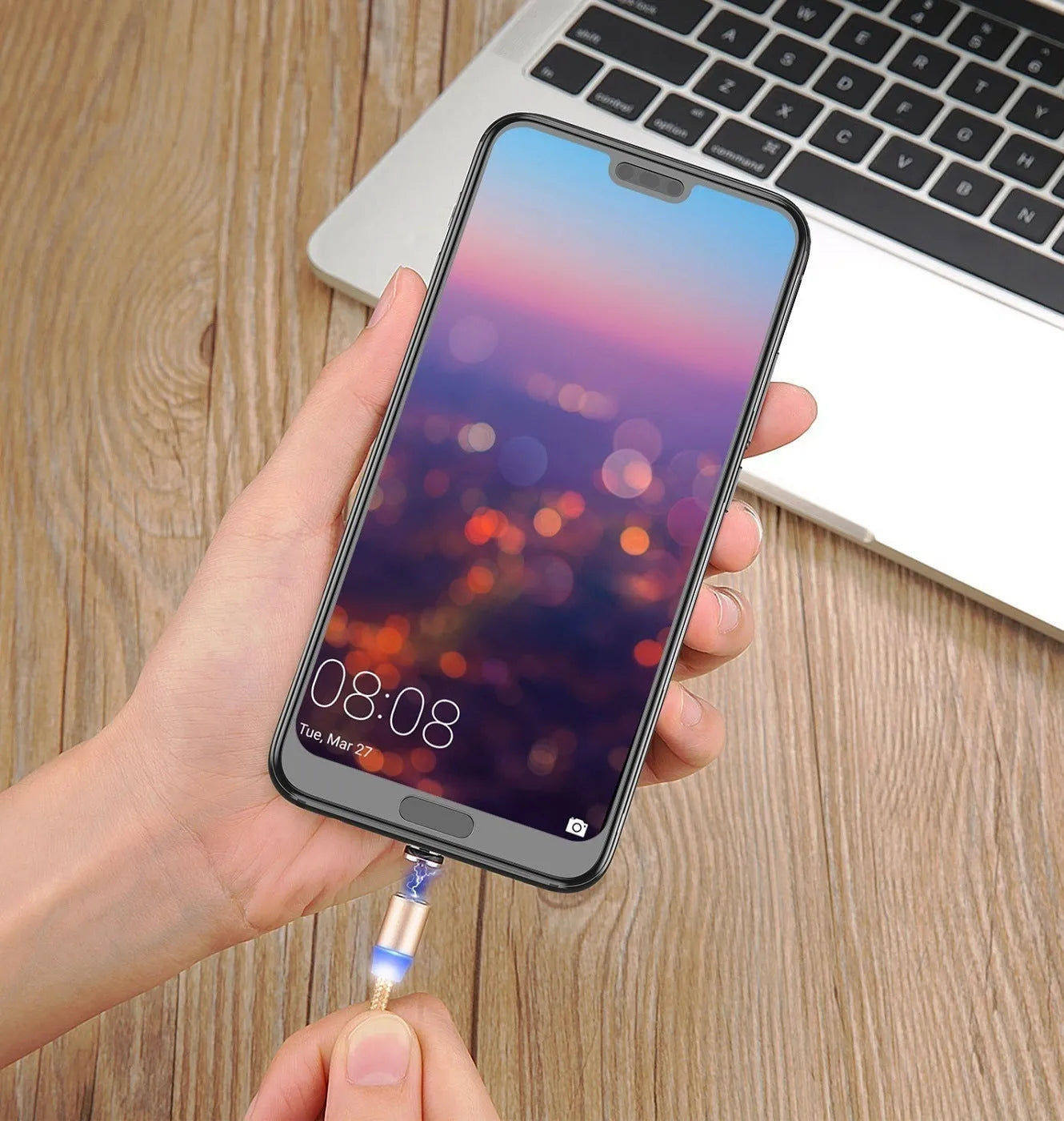 USLION magnetic data cable with aluminium ends, shown in black, connecting to a smartphone charging port.