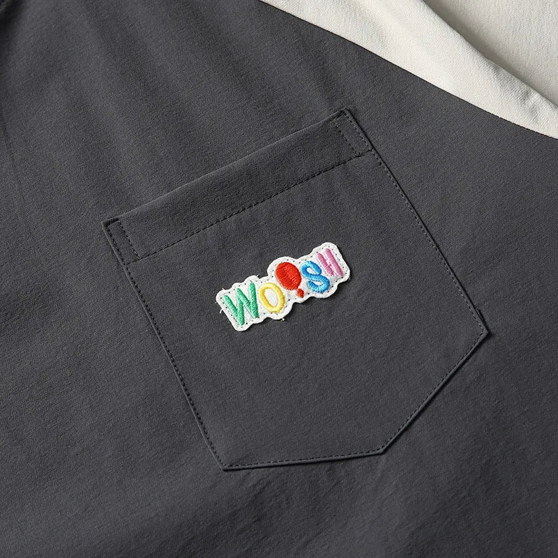 Dark grey men's loose-fit T-shirt with contrast raglan sleeves on a hanger.