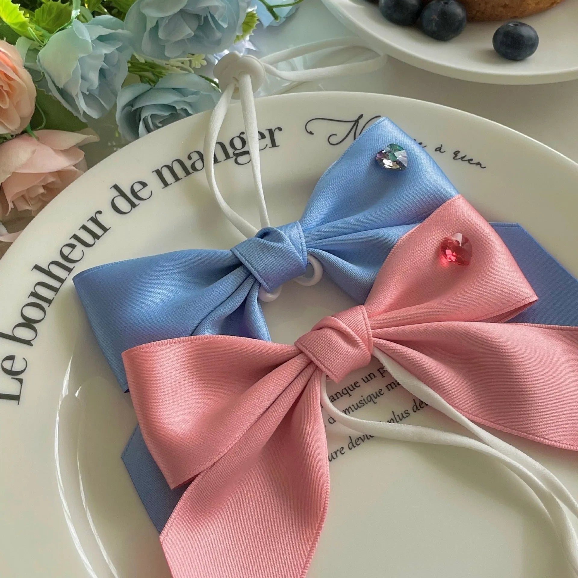 Blue adjustable princess bow hair band on a dog, showing the jacquard ribbon material and tension adjustment.