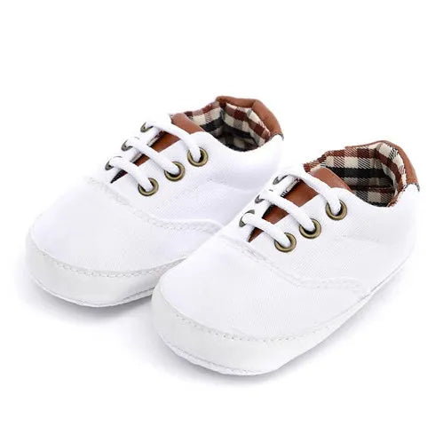 Solid colour baby canvas shoes with a front strap, shown in light grey on a white background.