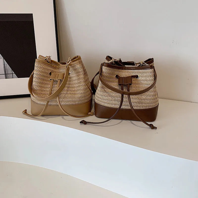 Woven straw women's crossbody bucket bag in brown colour showing horizontal square shape