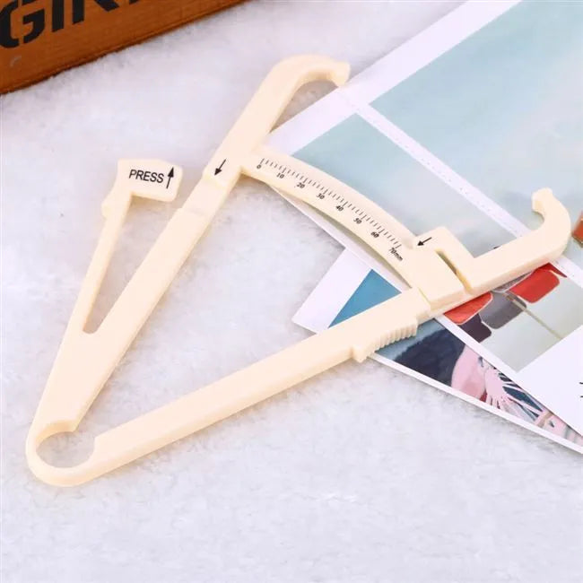 Acrylic skin fold caliper body fat measuring instrument showing scale and measurement jaws