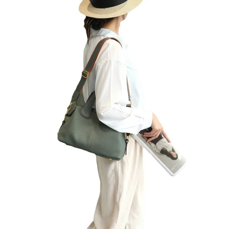 Black genuine leather women's cross-body shoulder bag with square shape and cross-body strap.