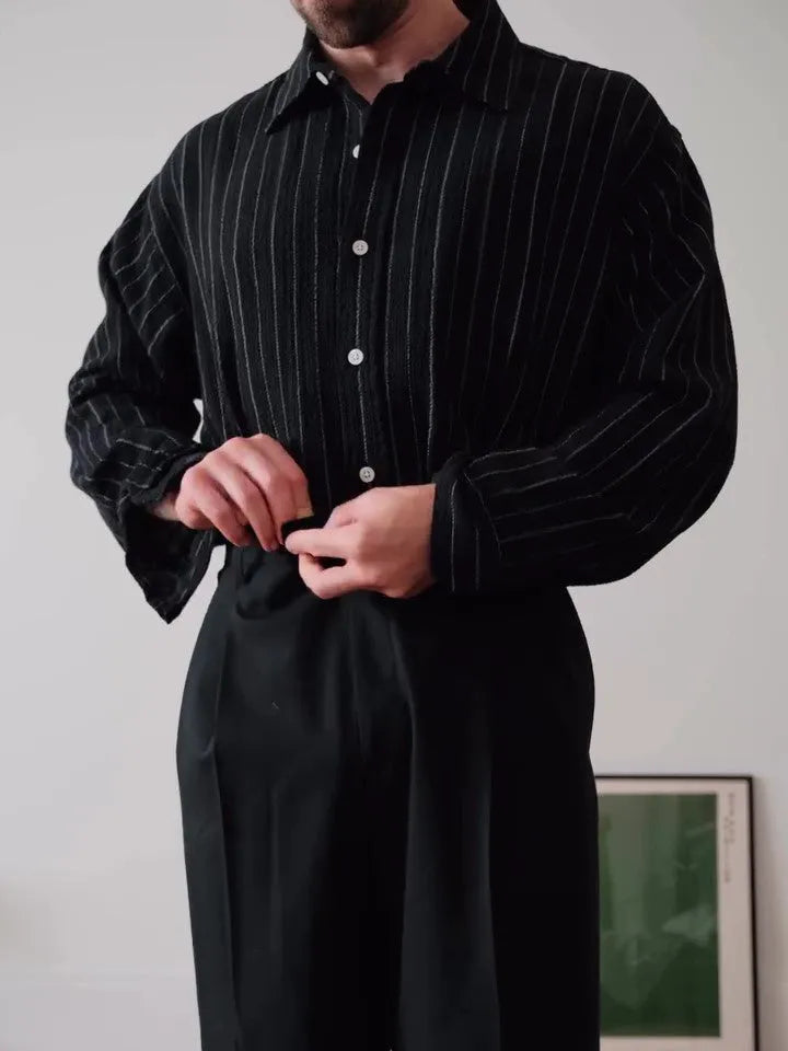 Men's black pinstriped button-down long sleeve shirt made from polyester fabric.