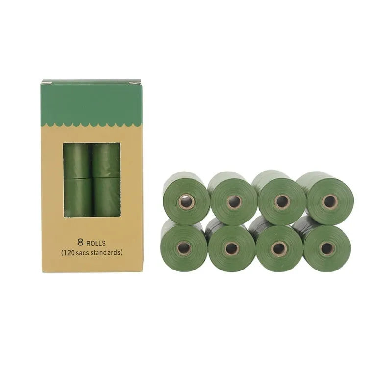 Roll of green EPI degradable pet poop bags next to a transparent dispenser on a dog lead.