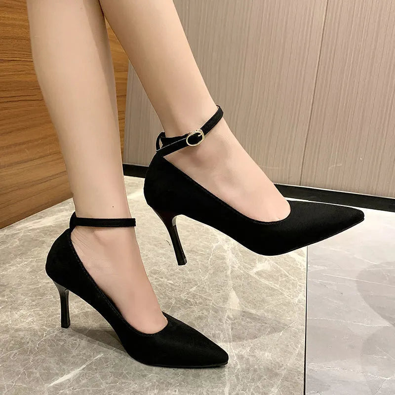Women's black stiletto pumps with skull pattern and buckle detail on rubber sole