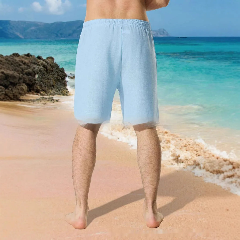 Man wearing blue loose-fitting casual shorts with a digital colour block pattern and a drawstring waist.