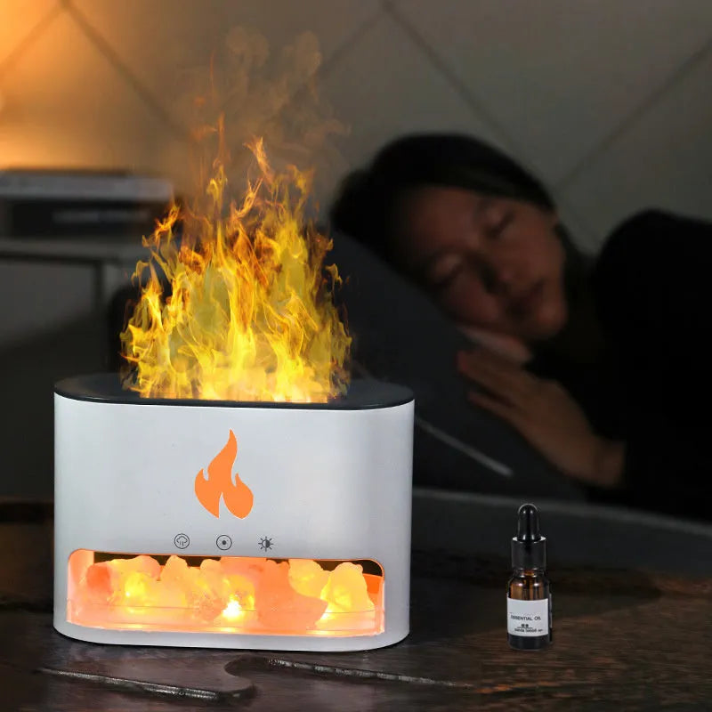 Square white flame humidifier on a desk showing a colourful 3D flame projection and a crystal salt stone.