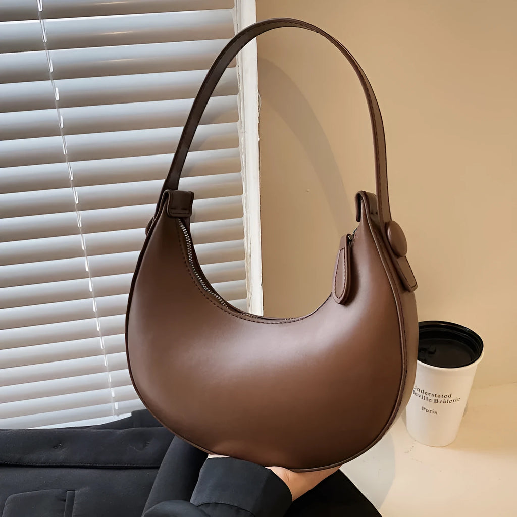 Women's retro dumpling-shaped PU shoulder bag in cream yellow with a zippered compartment.
