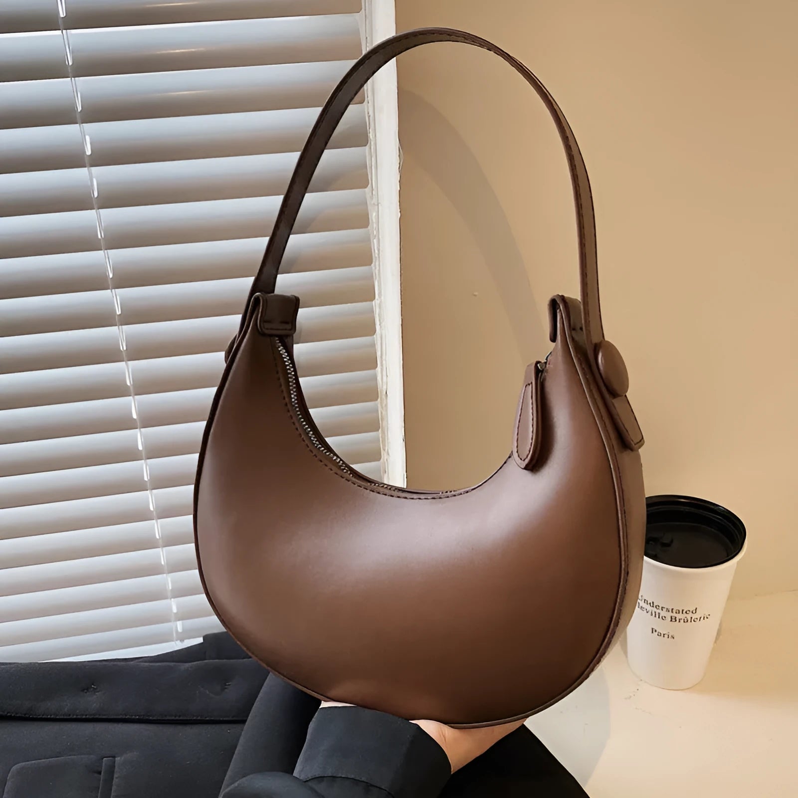 Women's retro dumpling-shaped PU shoulder bag in cream yellow with a zippered compartment.