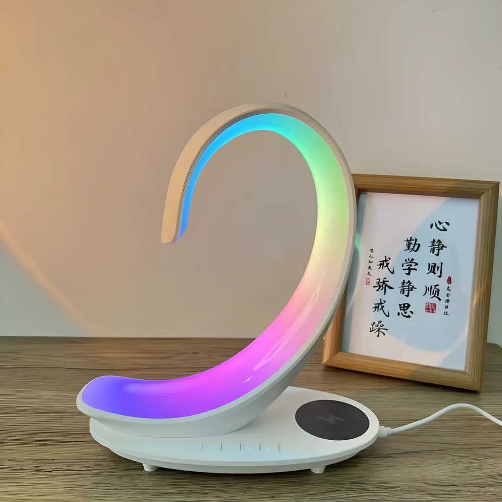 White swan-shaped desktop gadget with wireless charging pad, Bluetooth speaker, and colourful LED atmosphere light.