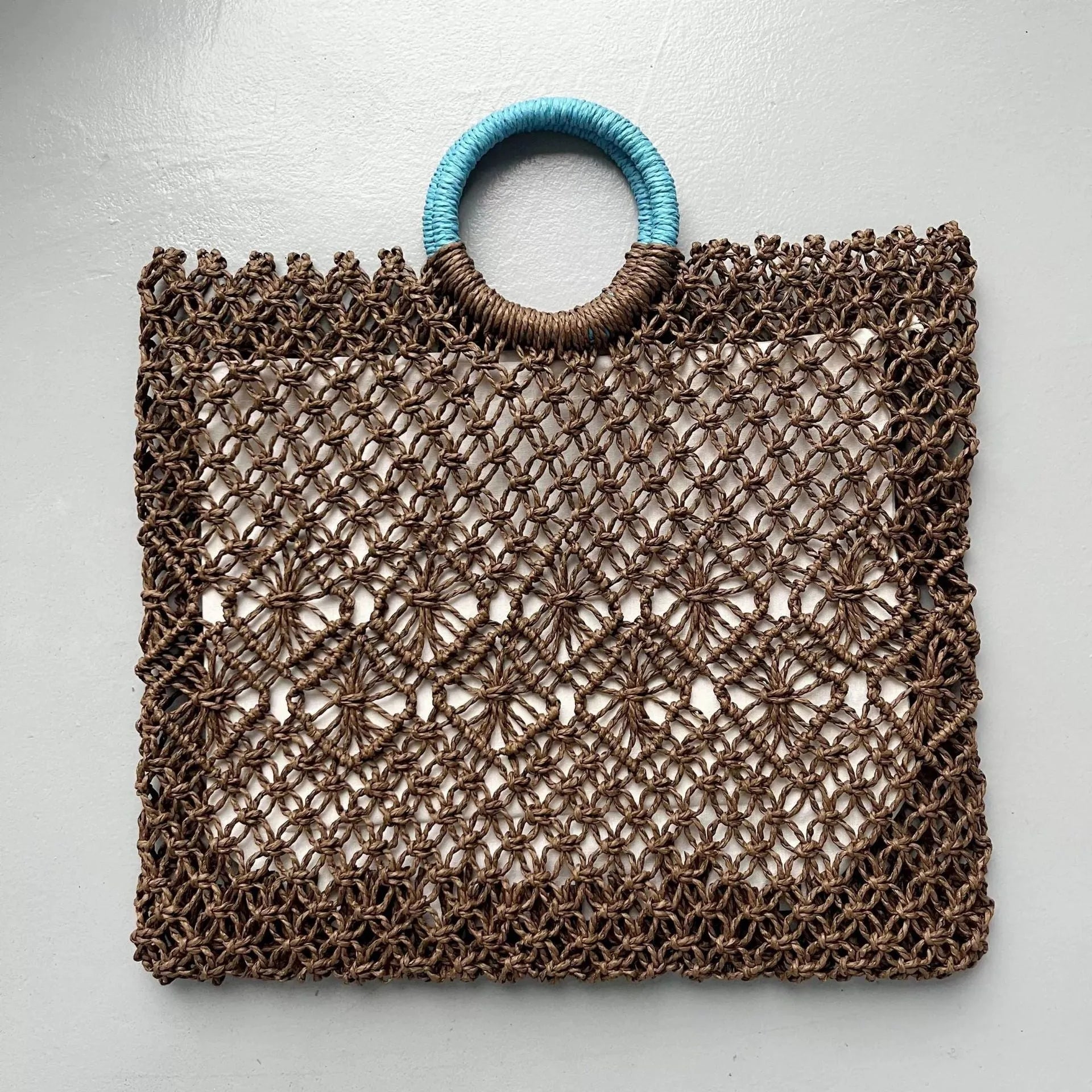 Dark brown handmade straw tote bag with square vertical shape and sandwich pocket design