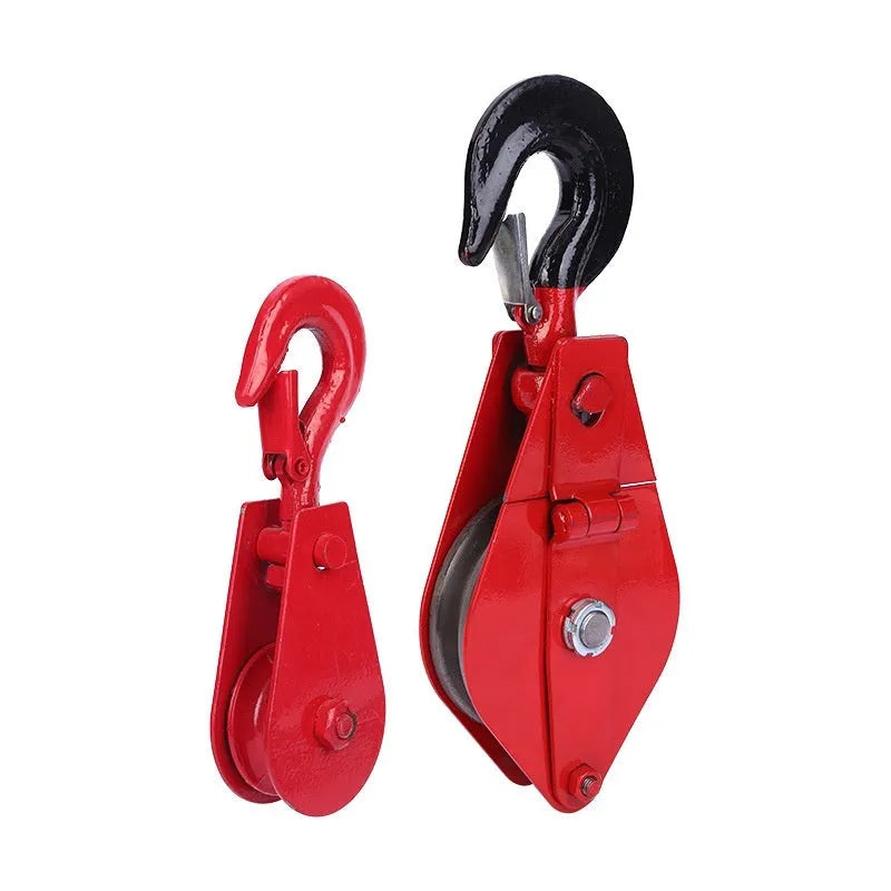 Red industrial single sheave lifting pulley with a safety latch on the steel hook.