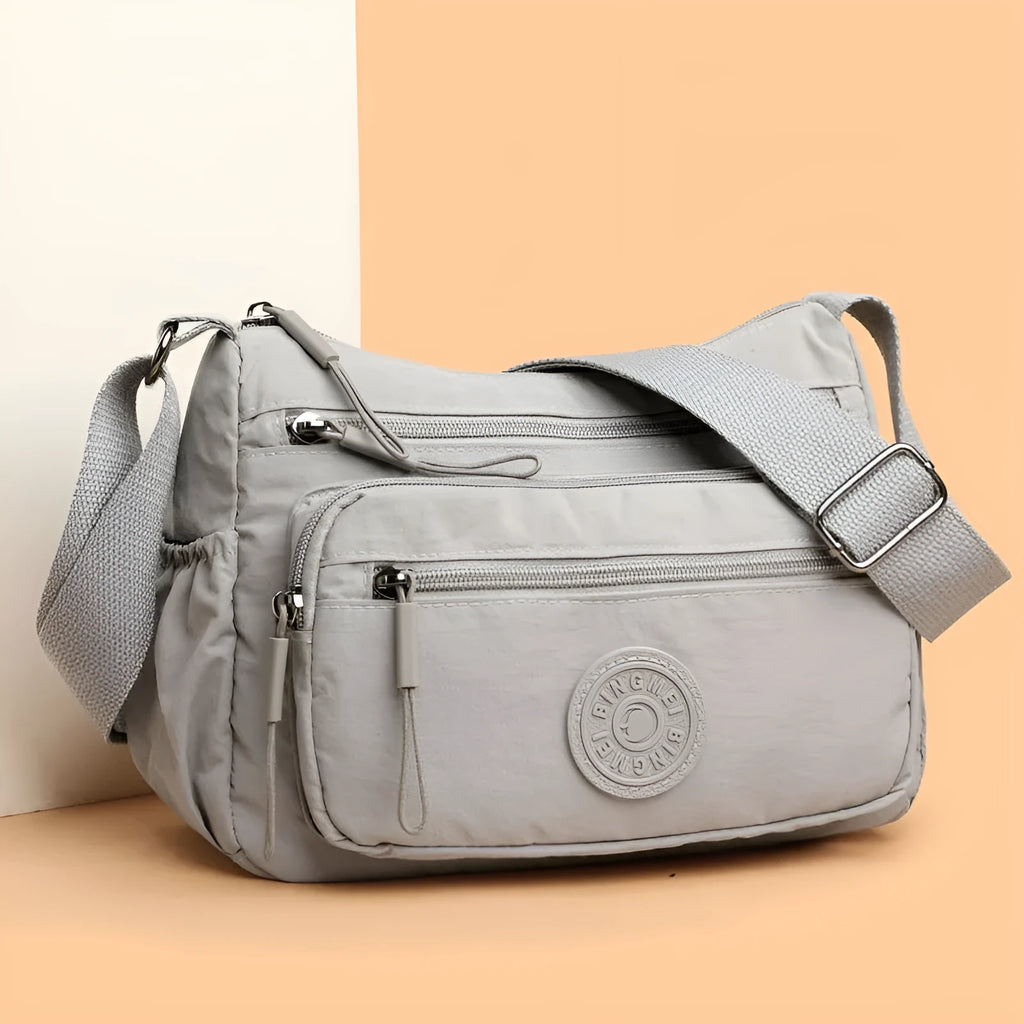 Water-repellent nylon crossbody bag with three-dimensional pocket shown in grey colour