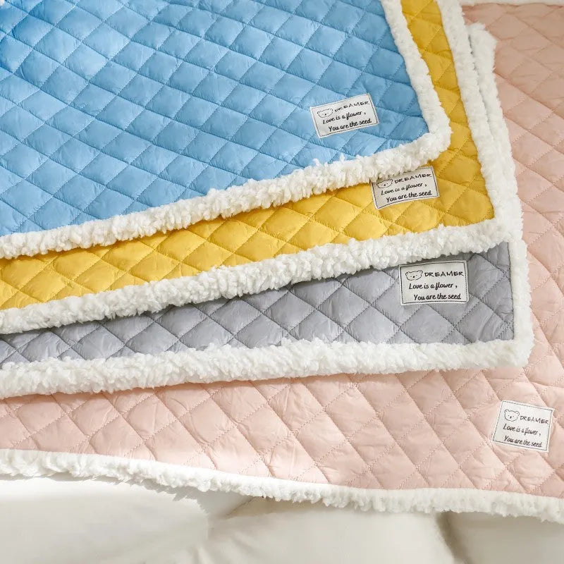 Quilted blue cloth pet blanket for cats, shown on a pet bed.