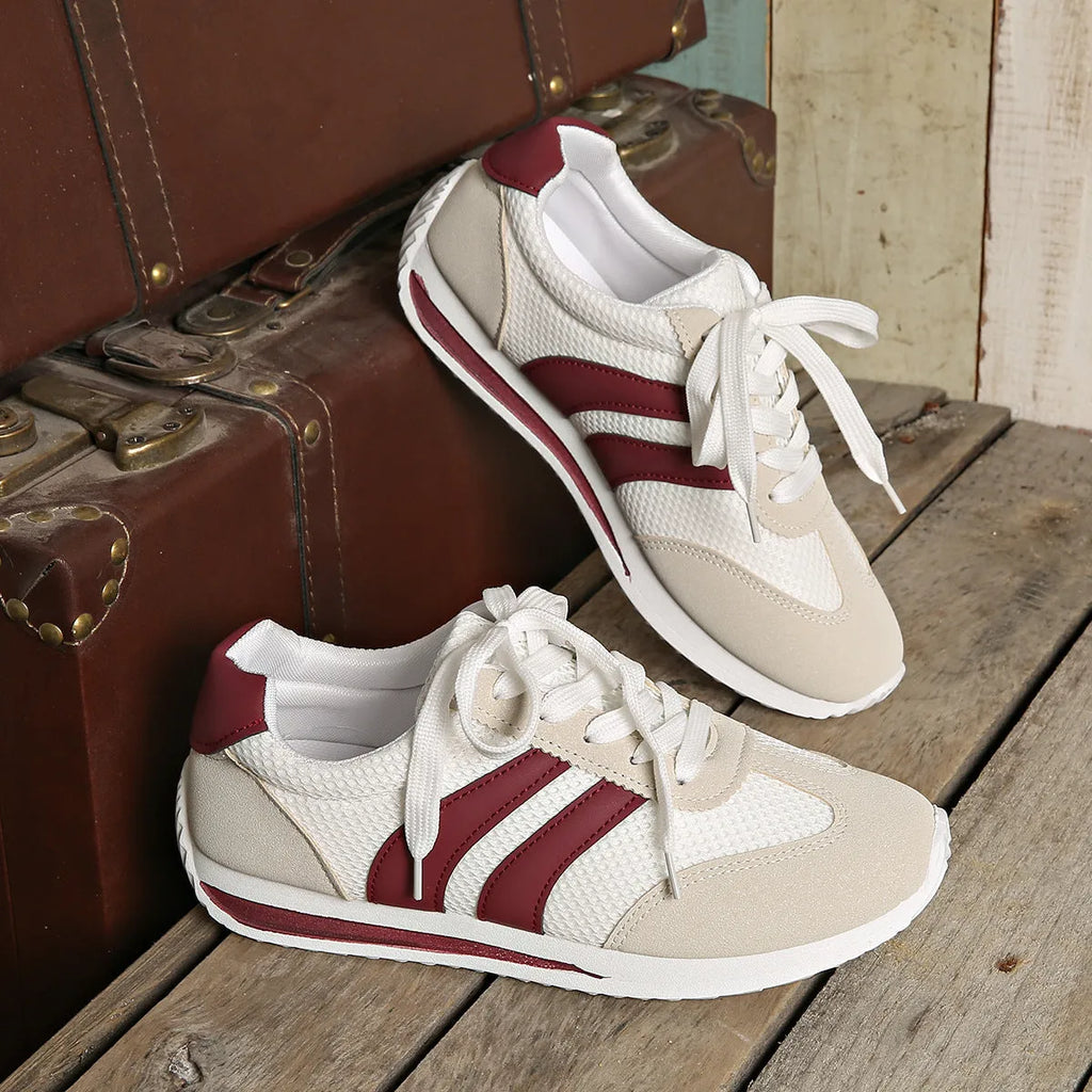 Wine red Cortez retro sneaker with cross straps, mesh lining, and flat rubber sole.