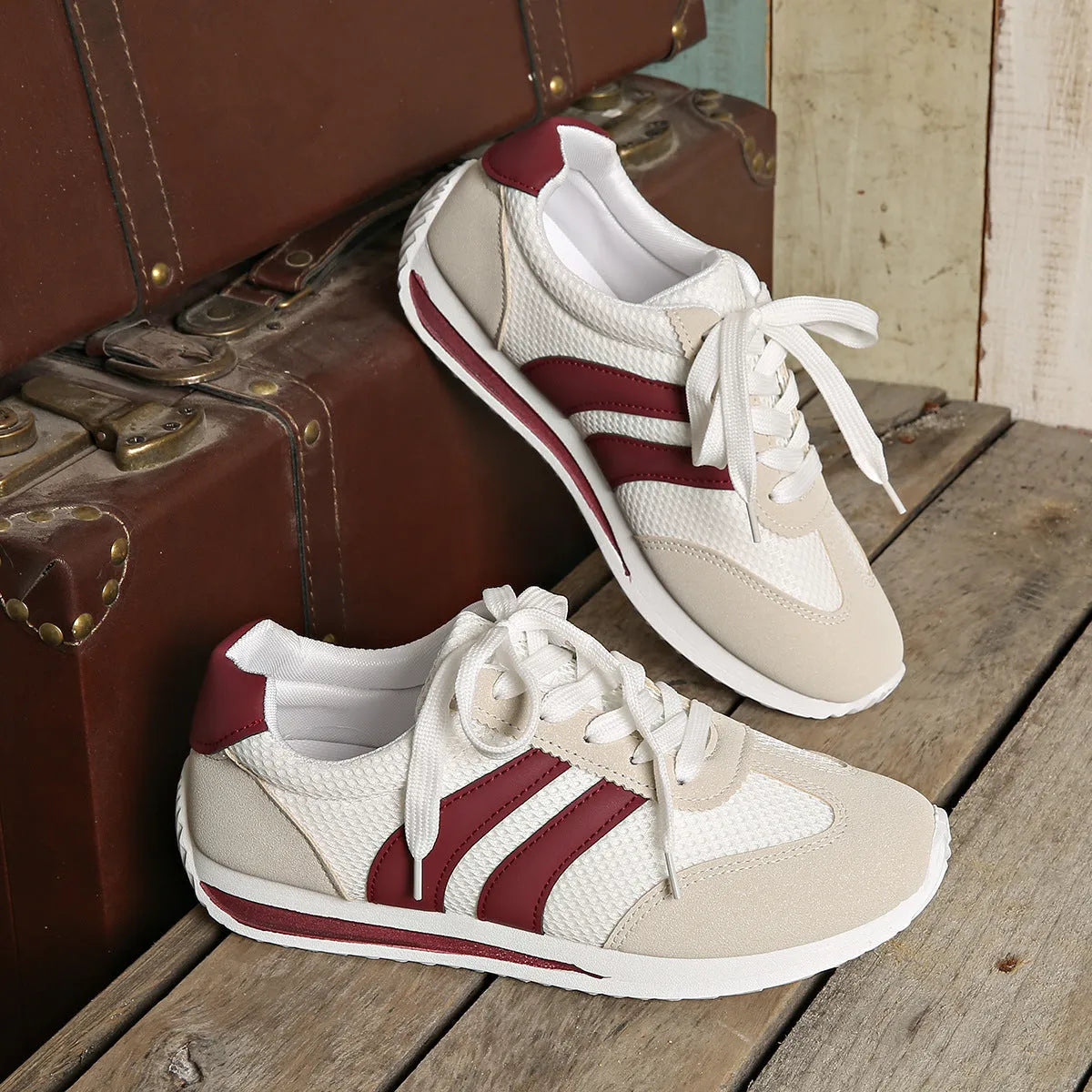 Wine red Cortez retro sneaker with cross straps, mesh lining, and flat rubber sole.